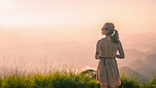 human woman standing on green grass looking side people
