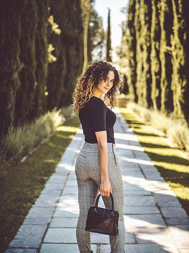 people woman standing on pathway between pine trees human