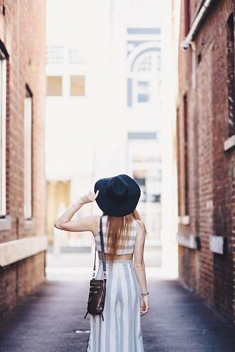 people woman standing on pathway holding hat human