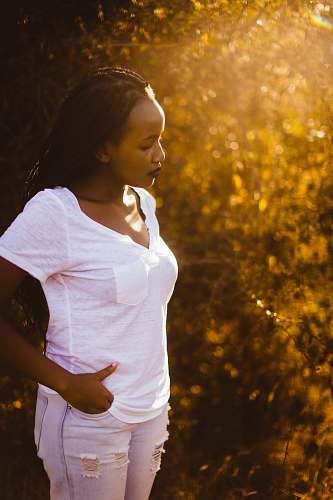 human woman standing while holding her pocket during daytime people