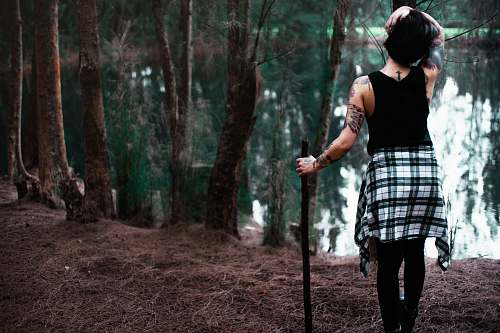 people woman standing while holding stick in front of body of water human