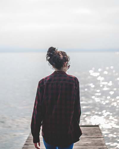 human woman wearing black and red gingham walking on wooden dock people