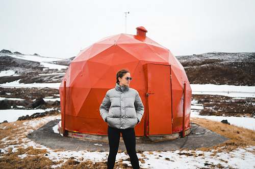 human woman wearing black pants near red metal dome house people