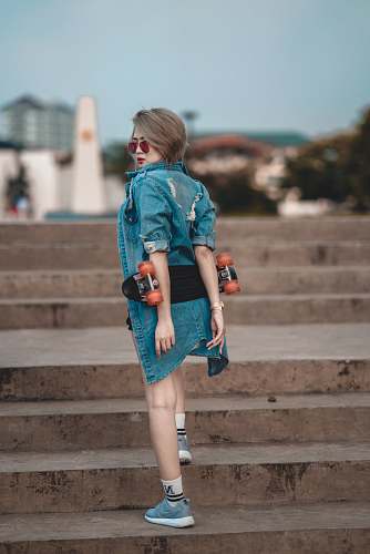 people woman wearing blue denim jacket walking on stair at daytime human
