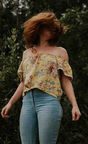 people woman wearing blue jeans standing behind plants human