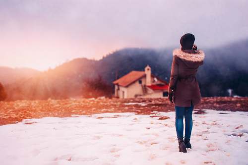 human woman wearing parka hoodie standing in front of house people
