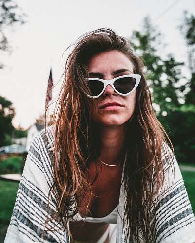 human women's black lens sunglasses and white bra people