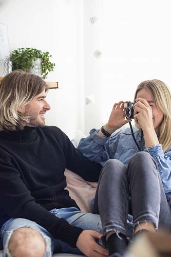 people man and woman sitting on pink sofa human