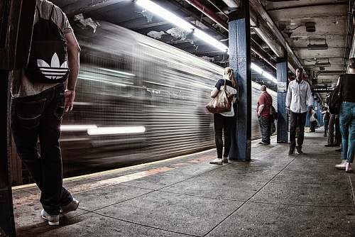 train time lapse photography of train beside people on station transportation