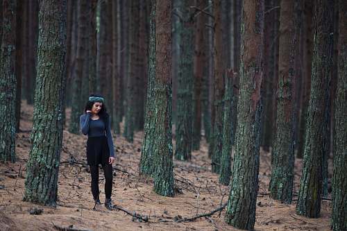 forest woman standing between trees during daytime outdoors
