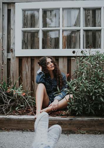 plant woman sitting under white wooden window people