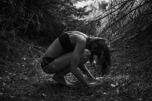  woman squatting and leaning forward while looking at her left 