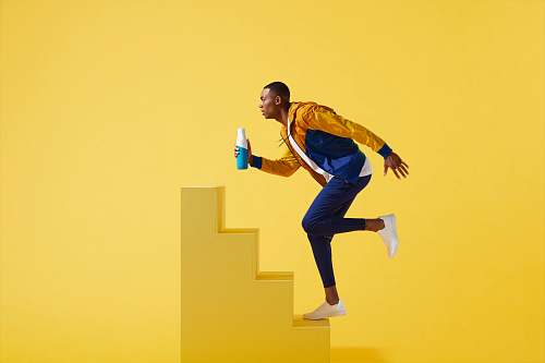 human man in blue and yellow jacket and blue pants on yellow stair person
