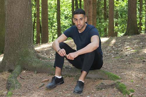 clothing man sitting on tree roots footwear