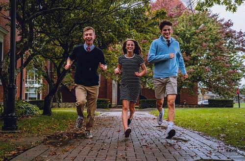 clothing two men and one woman running on pathway shorts
