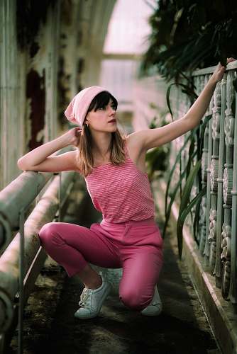 shoe woman in pink pants sitting beside railings footwear