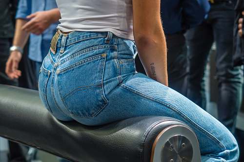clothing woman sitting on black leather surface close-up photographyt pants