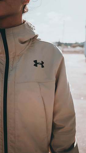 clothing woman standing while wearing white Under Armour zip-up jacket jacket