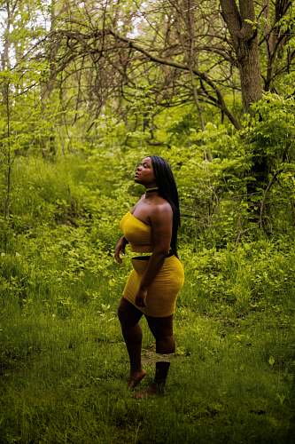 clothing woman wearing yellow strapless mini dress vegetation