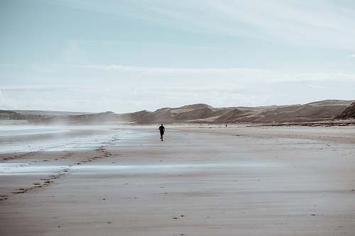 ocean person running on desert grey