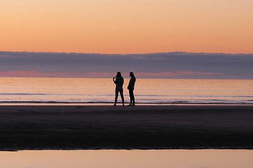 ocean silhouette of persons near in the beach sea