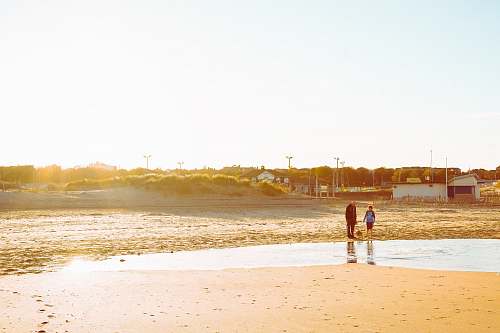 water two person walking with dog ocean