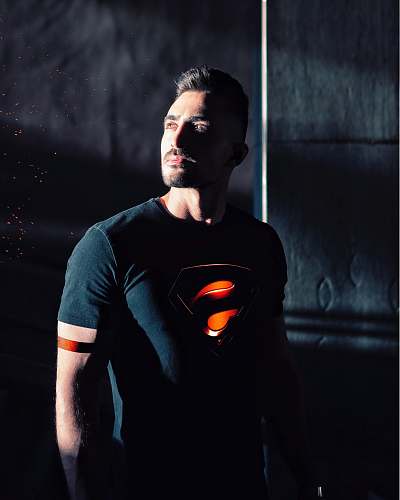apparel man wearing black Superman shirt sleeve