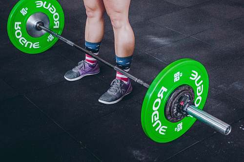 footwear person standing in front of gray and green barbell shoe