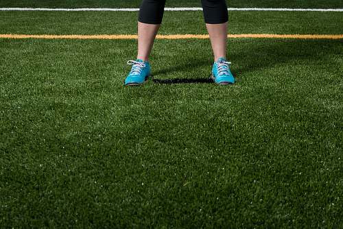 footwear person standing on green grass field shoe