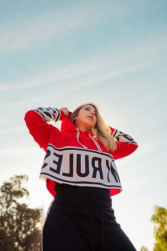 apparel shallow focus photo of woman in red and white pullover hoodie person