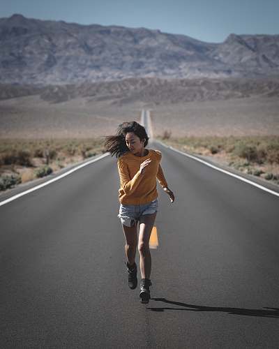 apparel woman running on road during daytime shorts