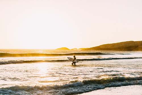ocean man holding his surfboard sea