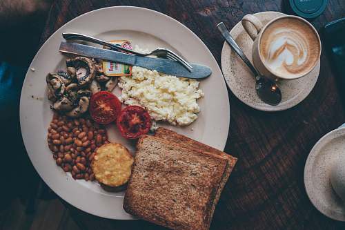 spoon food lot in a white plate near a knife and fork close-up photography ama cafe