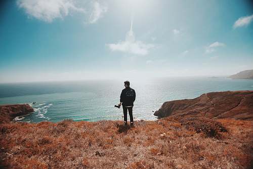 jogging man in black jacket standing on brown grass fitness