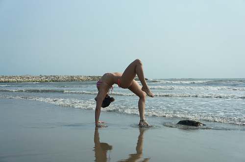 fitness woman stretching on shore near body of water yoga