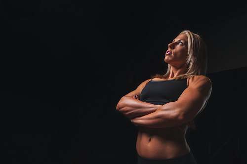 sports body builder woman wearing black crop-top cross armed closeup photography female