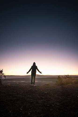 volcano silhouette of person standing on mountain top exercise
