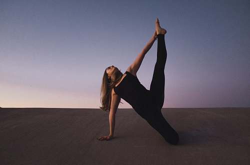 human woman holding her left leg high kneeling on floor person