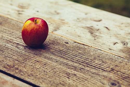 plant red apple on brown surface fruit