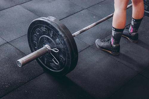 shoe person standing in front of gray and black barbell clothing