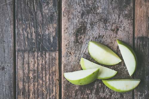 food five green apple slices on brown wooden panel apple