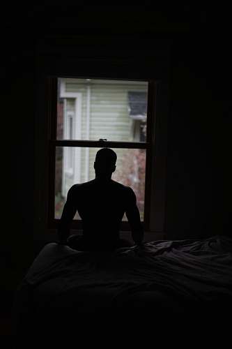 room man sitting on sofa beside window indoors