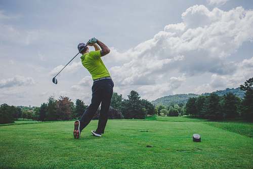 sports photo of man swinging golf driver sport