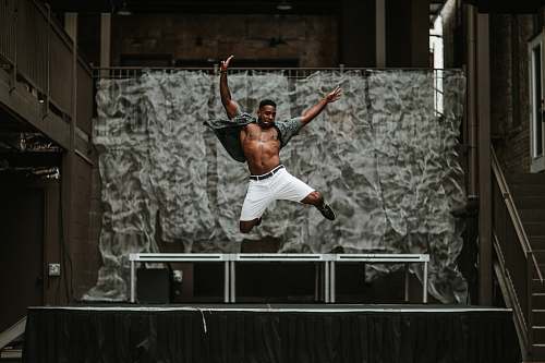 austin man raising his both hands while on air in front of stage united states