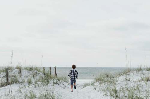 person boy running near body of water people