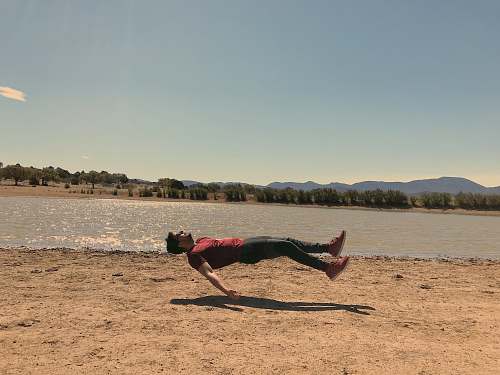 person floating man wearing red t-shirt during daytime apparel