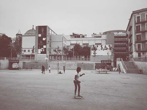 people girl ride on skateboard near building grey