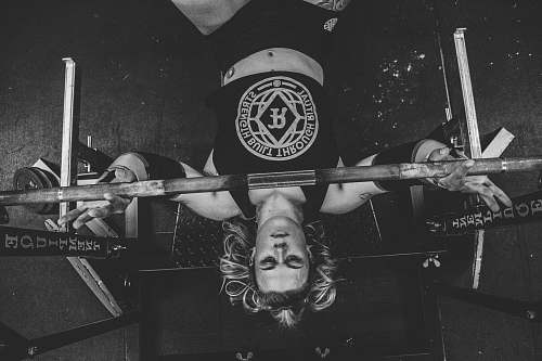 person grayscale photo of man carrying barbell black-and-white