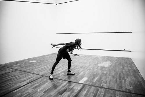 person grayscale photography of person holding racket black-and-white