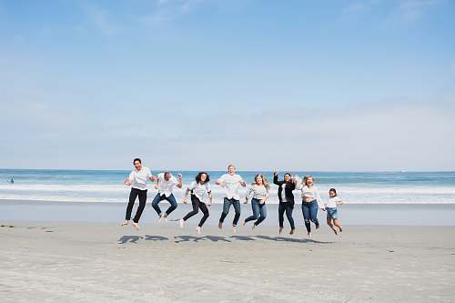person group of people jumping on seashore people